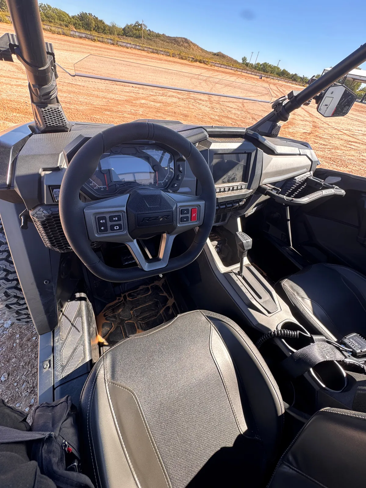 Driver's view of the RZR Pro S Ultimate "Ninja" cockpit with the steering wheel controls, digital gauge, center touchscreen and gear selector